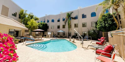 Swimming pool area with lounge chairs and umbrellas