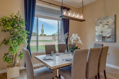 Bright dining room with a large window and floral decor