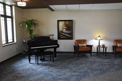 A cozy common area with a piano and seating