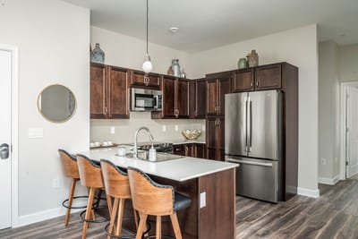 Modern kitchen interior with wood cabinetry and bar stools