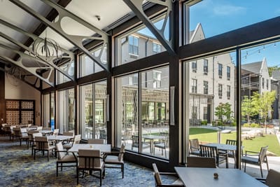 Bright common area with large windows leading to outdoor space