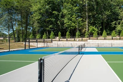 Tennis courts surrounded by trees in a facility outdoor space