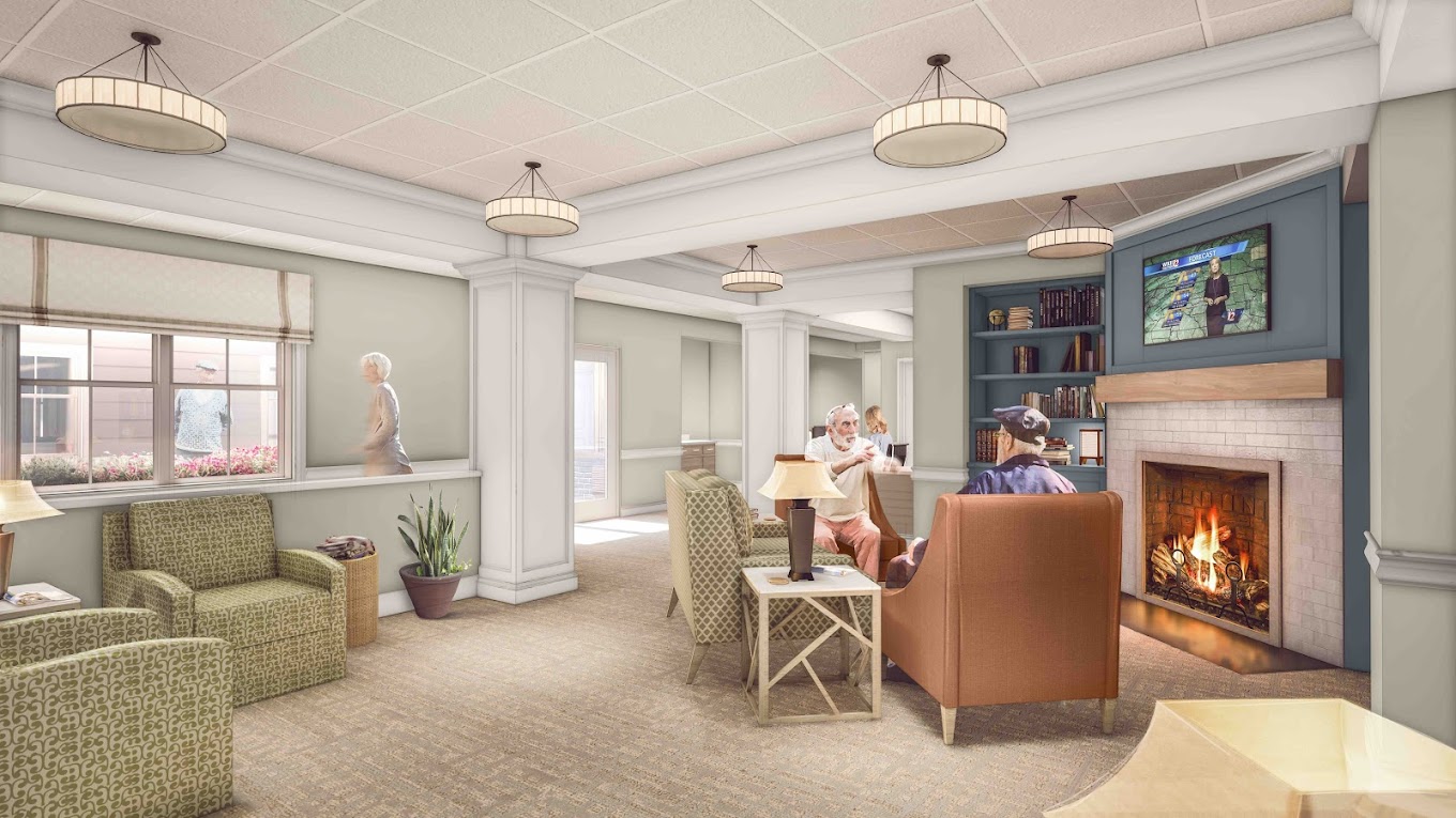 A cozy common area with residents by a fireplace