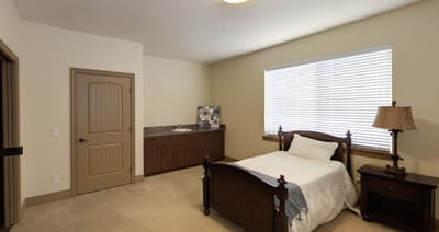 A well-furnished private resident room with a bed and a window