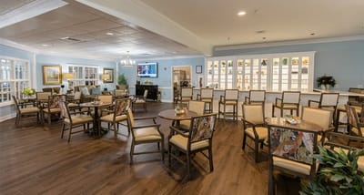 Bright common area with tables and chairs in a retirement community