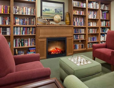 Cozy common area with bookshelves and fireplace