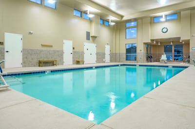 Indoor swimming pool area with clear water and seating
