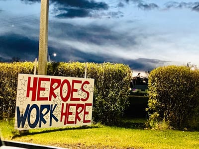 Sign displaying 'Heroes Work Here' outdoors
