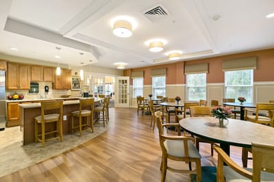 Bright common area with dining tables and kitchen
