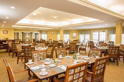 Bright dining room setup with tables and floral decor