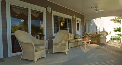 Outdoor seating area with wicker chairs and flower pots
