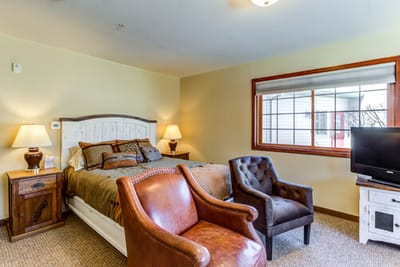 A well-furnished private resident room with a bed and seating