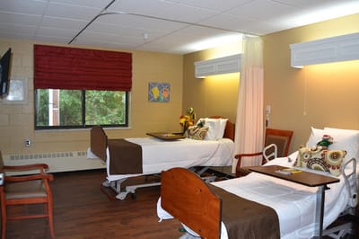 A shared resident room with two beds and a window