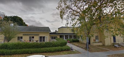 Exterior view of Ethan Allen Residence with residents outside