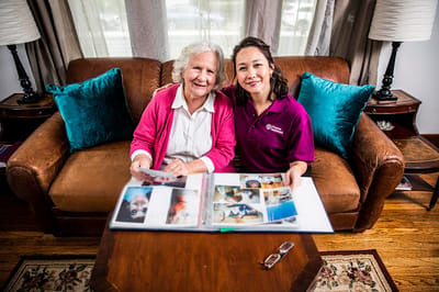 A caregiver and resident looking through a photo album