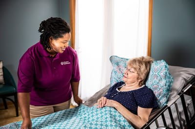 Caregiver assisting a senior resident in a private room