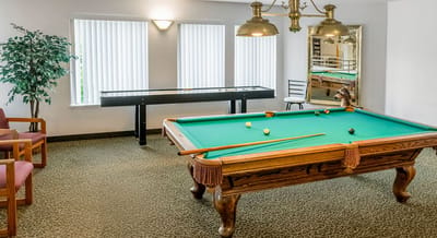 A billiard table and seating in a common area
