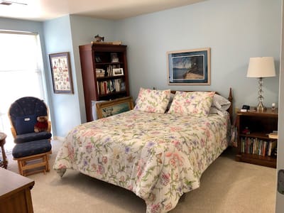 Cozy bedroom with floral bedding and bookcase