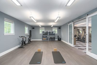 Well-equipped fitness room with exercise bikes and weights