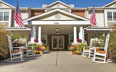 Front entrance of a senior living facility with rocking chairs