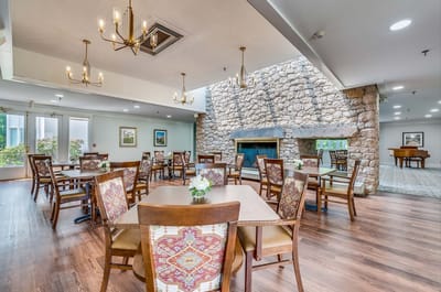 Interior dining area with wooden tables and stone wall.