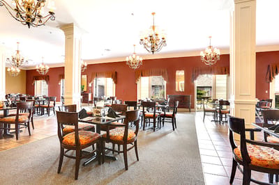 Bright dining area with elegant chandeliers and tables.