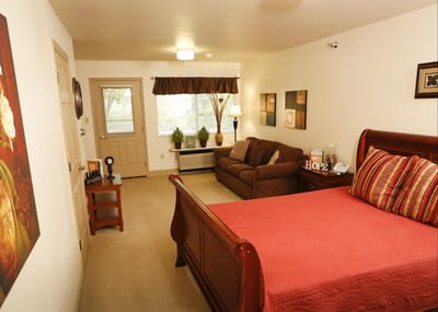 Cozy interior of a resident's room with a bed and seating area