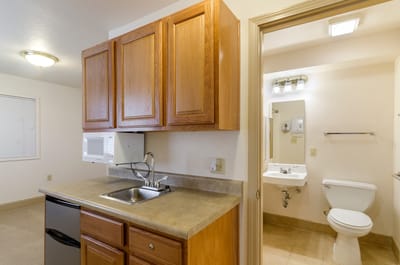 Interior view of a kitchen and bathroom area in a resident room