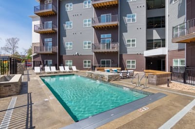 Swimming pool area with lounge chairs and sunny sky