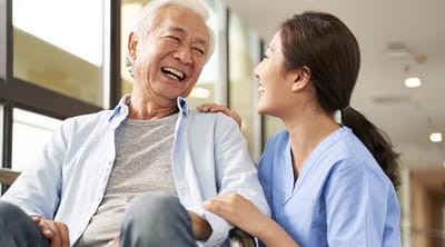 Caregiver and senior man sharing a joyful moment