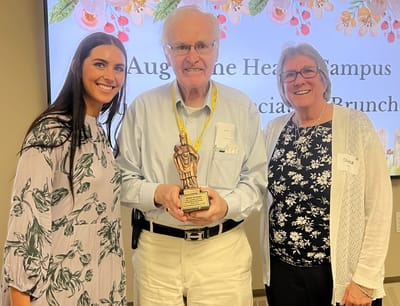 Staff presenting an award at a celebration event.