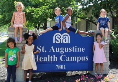Children posed by the facility sign outside.