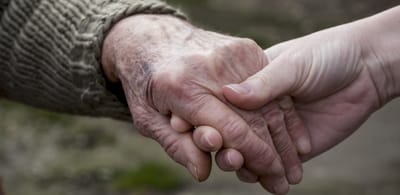 Two hands clasping in a gesture of support.