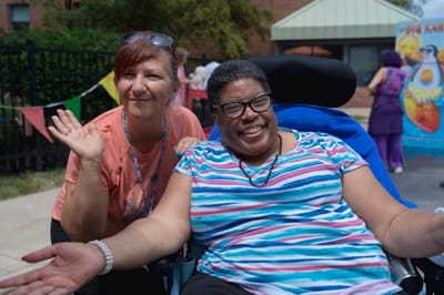 Staff member and resident enjoying an outdoor event.