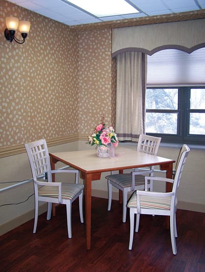Cozy common area with a dining table and flower vase.