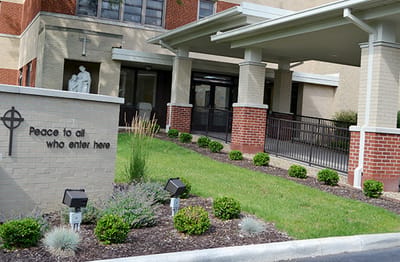 Entrance area with greenery and welcoming sign.