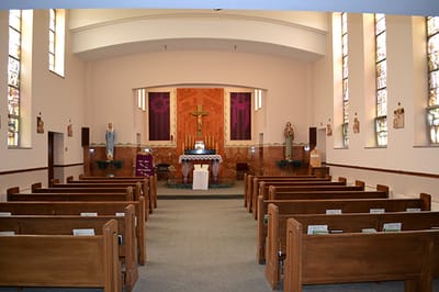 Interior view of a chapel with wooden pews.