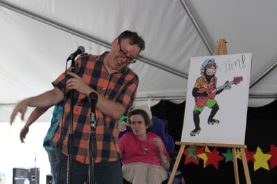 Person performing with a painting in a festive setting.