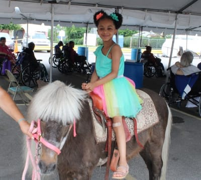 Child riding a pony at an outdoor event