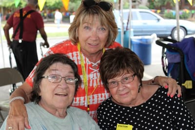 Three women posing together with cheerful expressions.