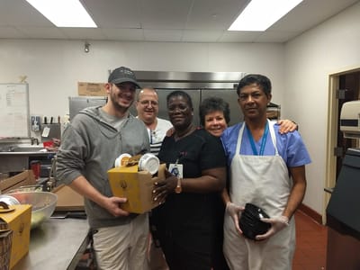Staff members in a kitchen preparing food.