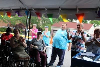 Residents and staff celebrating at an outdoor event.