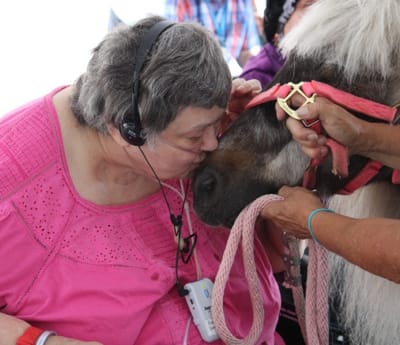 Resident interacting with a pony during a therapeutic event.