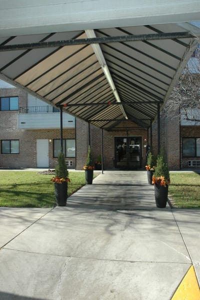Covered entrance with landscaping leading to the facility
