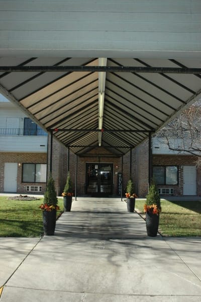 Covered entrance with landscaped planters leading to the facility