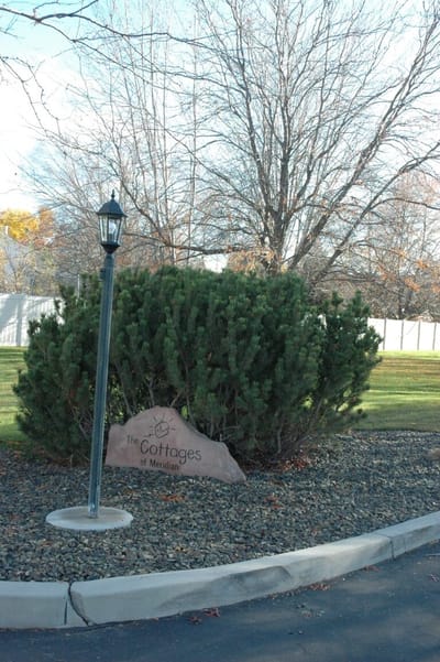 Sign for The Cottages of Meridian near a landscaped area