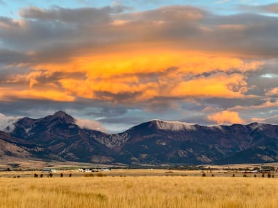 Scenic view of mountains and fields at sunset