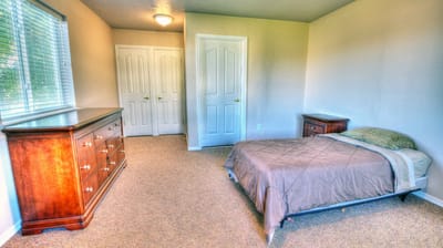 Simple private bedroom with a single bed and dresser