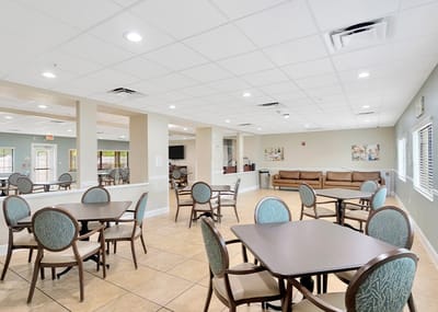 Common area with tables and chairs in bright interior