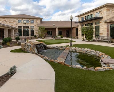 Beautiful landscaped outdoor space with pond and seating area